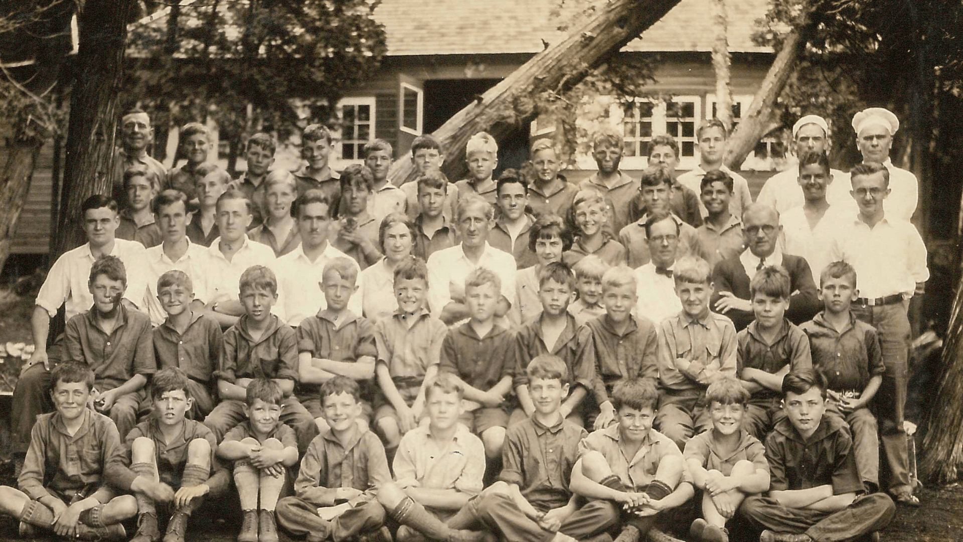 Vintage group portrait of young boys and men at camp