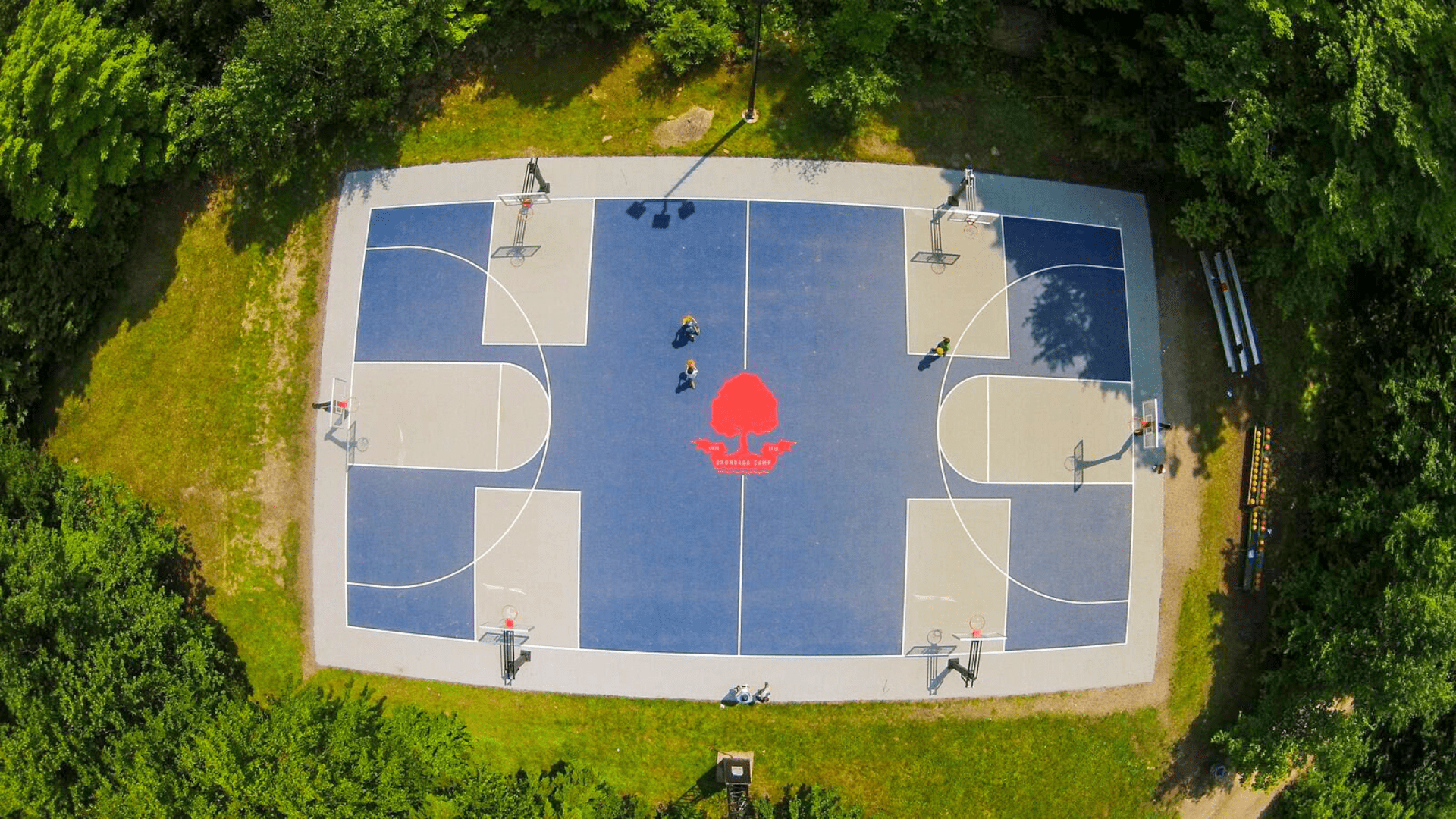 Aerial view of a blue basketball court with red logo.