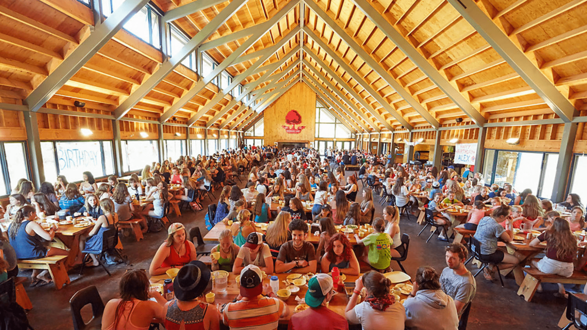 A large dining hall filled with campers sitting at tables.