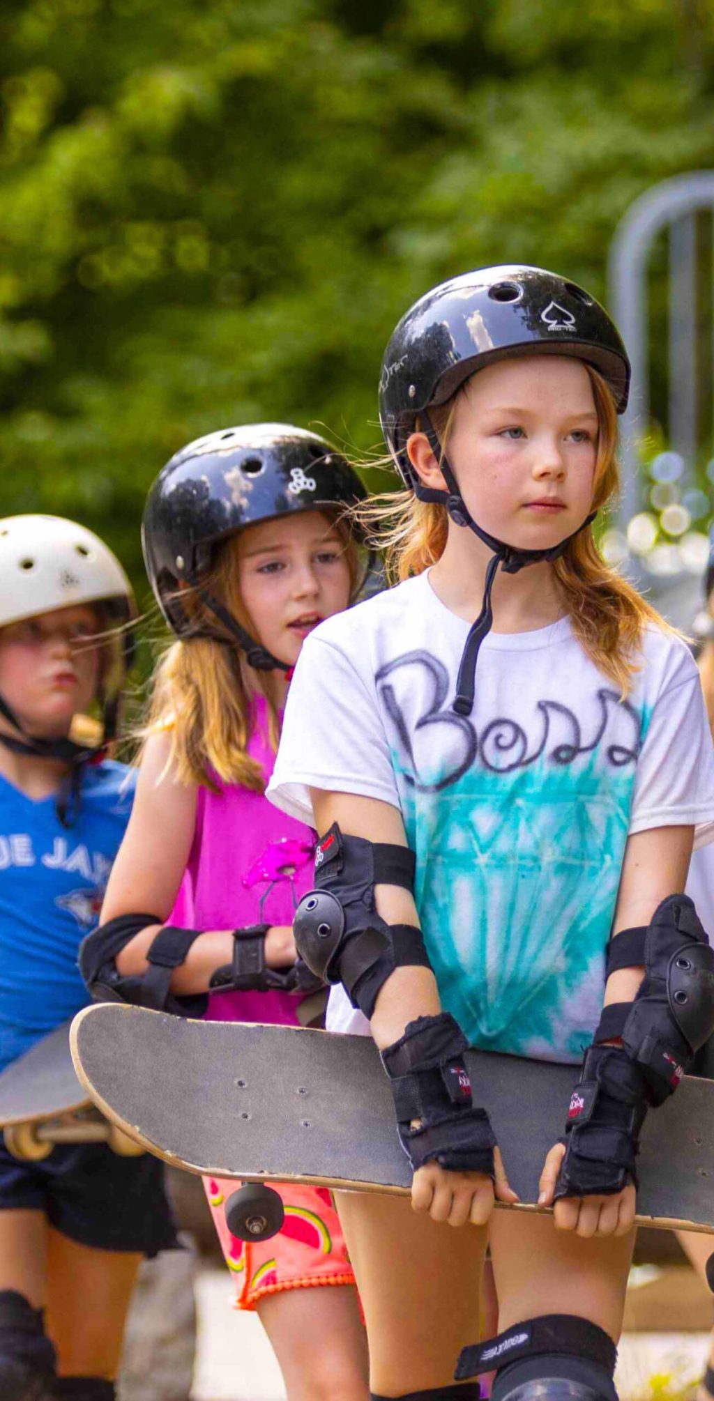 Young campers wearing helmets and safety pads.