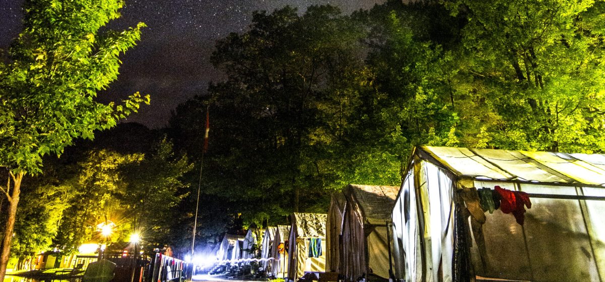 Line of illuminated tents at night time.